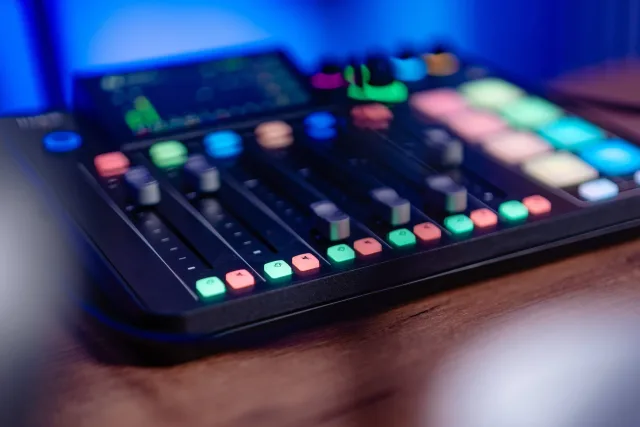A Rodecaster Pro hangkeverő közeli képe színes pad-gombokkal a stúdió asztalán