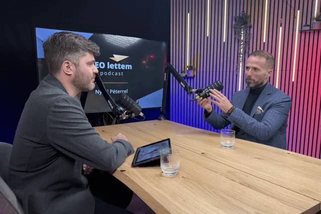 Podcast felvétele vendéggel, háttérben a CEO lettem podcast kijelzője és kamera