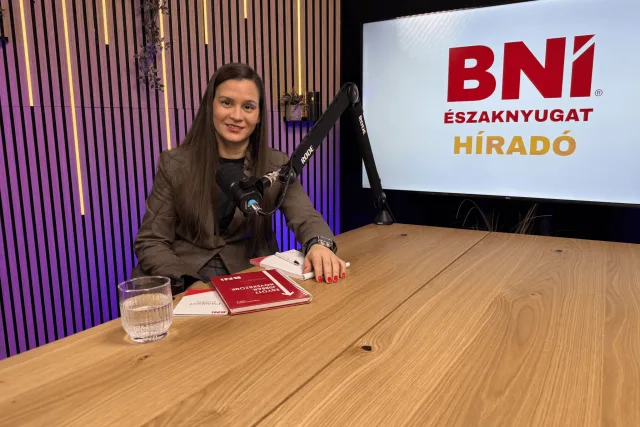 Vendég felvétel közben mikrofonnal, háttérben a BNI Északnyugat Híradó kijelzője